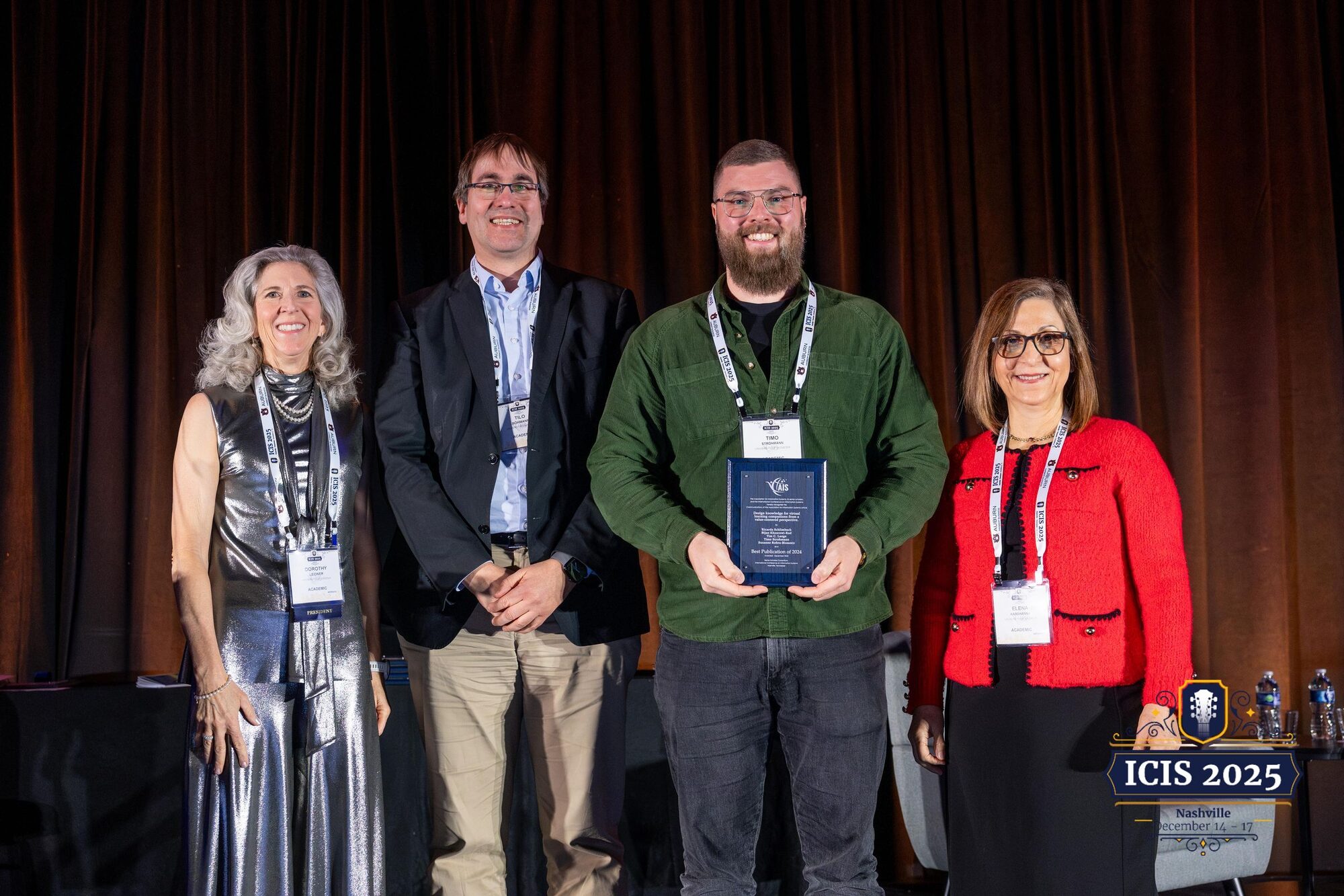 Timo Strohmann holding the award plaque on stage at ICIS 2025 in Nashville, standing with three representatives of the Association for Information Systems